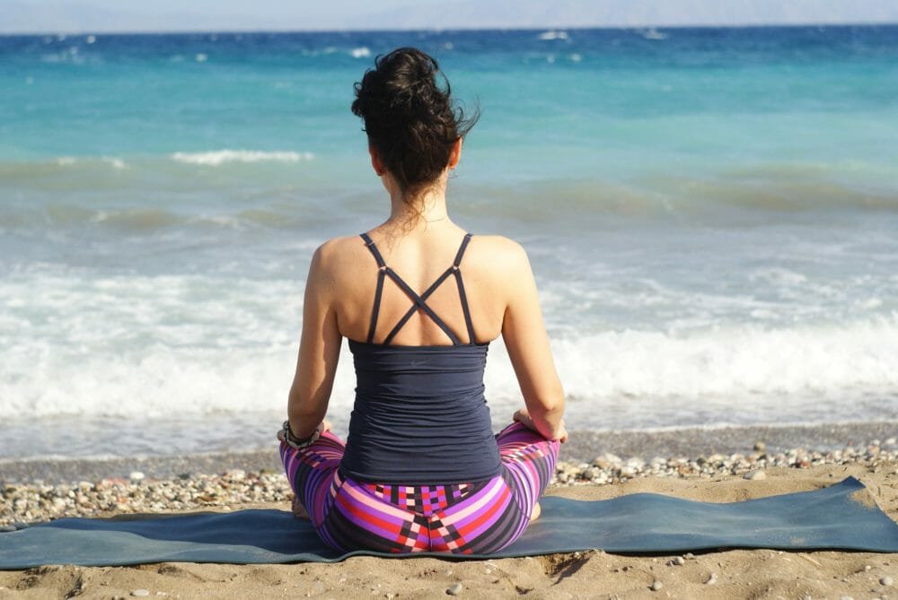 Photo of woman meditating on a beach