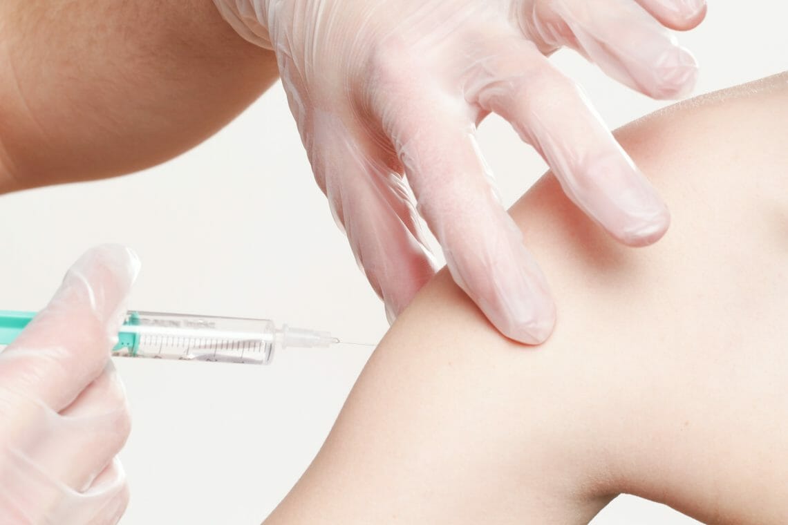 Nurse giving vaccination shot to a patient